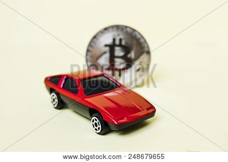 Close-up View Of Bitcoin And Red Car.