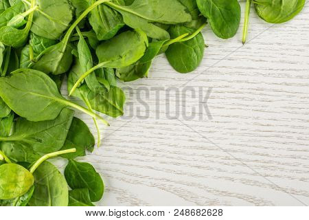 Fresh Baby Spinach Leaves Top View On Grey Wood Background Left Upper Corner