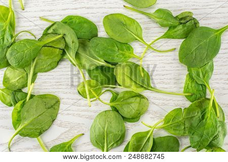 Fresh Baby Spinach Leaves Top View On Grey Wood Background