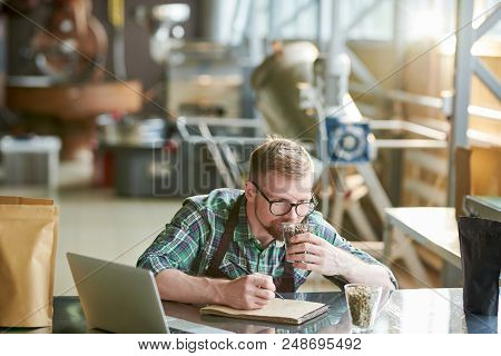 Portrait Of Modern Barista Holding Coffee Beans And Making Notes While Checking Quality Of Roast In 