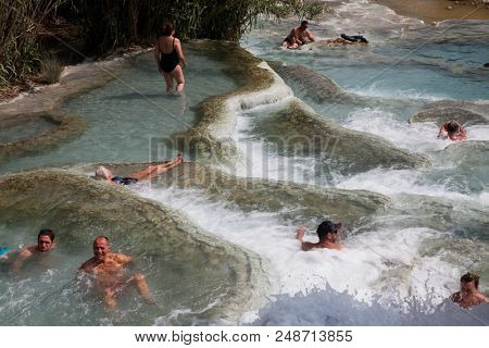 GROSSETTO, TUSCANY, ITALY - MAY 2018: unidentified people bathing in natural spa with waterfalls and hot springs at Saturnia thermal baths