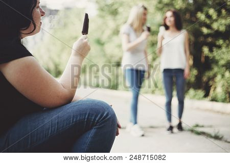 Unhealthy Lifestyle, Excessive Weight, Overeating, Obesity. Overweight Woman Sit In The Street Eatin