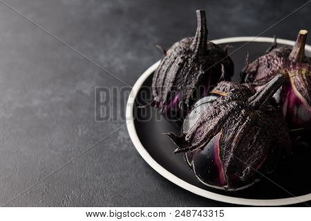Fresh Italian Type Eggplants Or Aubergines With Water Drops In Black Plate On Dark Stone Background