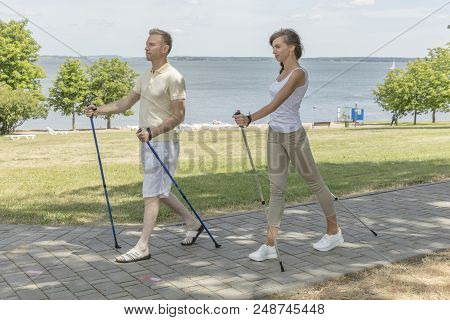Young Couple Hiking In The Nature Nordic Walking