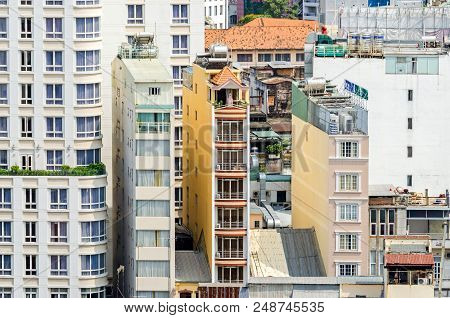 Ho Chi Minh City, Vietnam - 4 April, 2018: A Few Remaining Typical Narrow Old Buildings In A Fast Gr