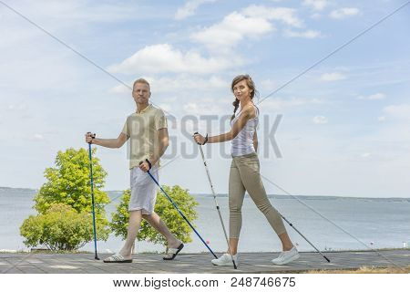 Young Couple Hiking In The Nature Nordic Walking