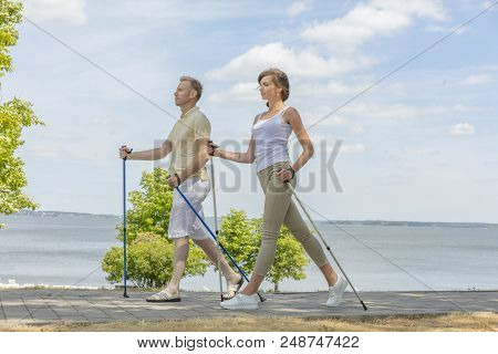 Young Couple Hiking In The Nature Nordic Walking