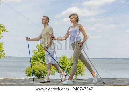Young Couple Hiking In The Nature Nordic Walking