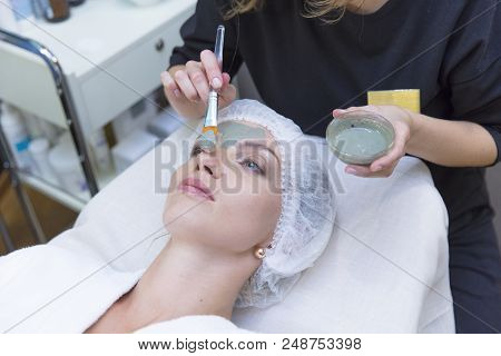 Young Beautiful Girl Receiving Pink Mask In Spa Beauty Salon - Indoors