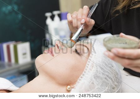 Young Beautiful Girl Receiving Pink Mask In Spa Beauty Salon - Indoors