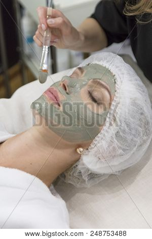 Young Beautiful Girl Receiving Pink Mask In Spa Beauty Salon - Indoors