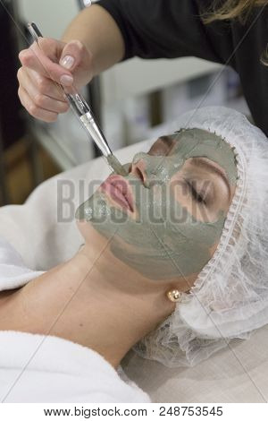 Young Beautiful Girl Receiving Pink Mask In Spa Beauty Salon - Indoors