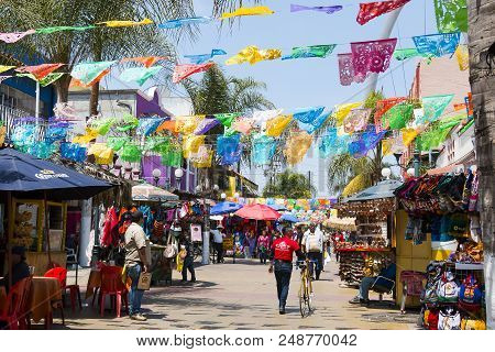 Tijuana, Baja California/mexico - June 20, 2018:  People Shop Beneath The Colorful Hanging Flags At 