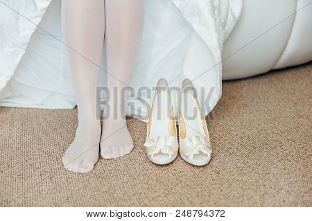 Beautiful Woman Legs In Whitel Shoes. Wedding Dress And Shoes. Morning Of The Bride.