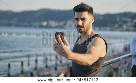 Young Man At Beach Taking Selfie Photo With His Cell Phone