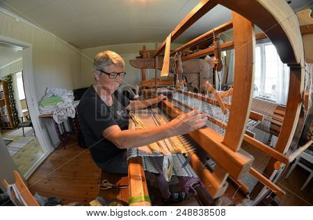 Norwegian woman works with traditional loom. June 19,2018. Rakkestad,Norway