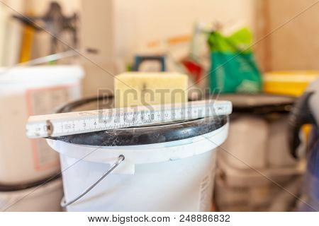Double Meter Stick Lies On A White Bucket