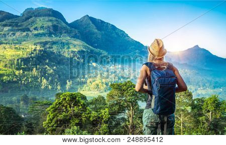 Rear view of a young tourist girl enjoying amazing beauty of tropical nature of Nuwara Eliya, Sri Lanka, active summer vacation on exotic island