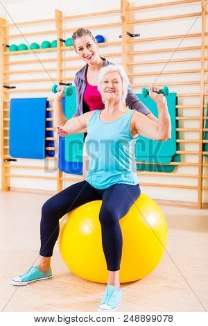 Senior woman with trainer doing fitness sport in gym