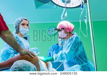 Cosmetic Liposuction Surgery In Actual Operating Room Setting Showing Surgeon Hands And Cannula