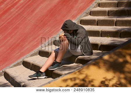 Sad Troubled Hispanic 13 Years Old School Boy Teenager Alone Wearing A Hoodie Posing Outdoor - Close