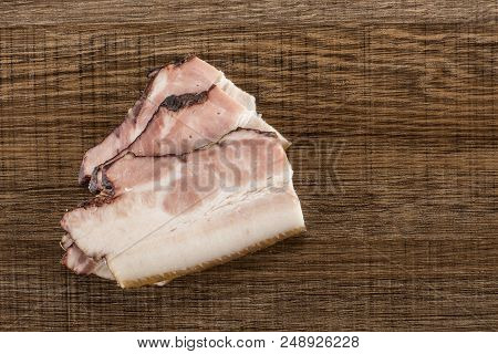 Group Of Three Slices Of English Bacon Flatlay On Brown Wood