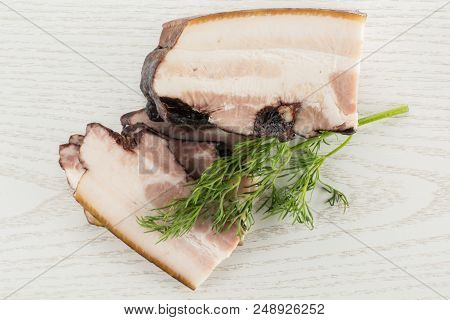 Group Of Three Slices One Piece Of English Bacon With A Sprig Of Dill Flatlay On Grey Wood