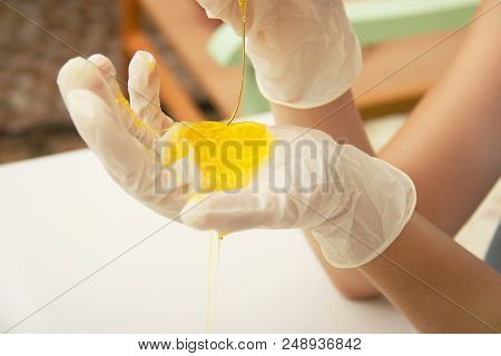 How To Make Slime. A Female Hand In A Protective Glove Holds Yellow Homemade Slime Is A Children's T
