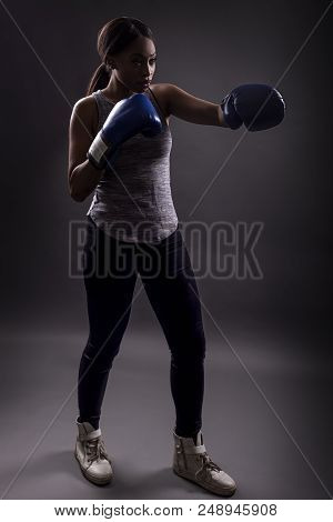 Black Female Wearing Boxing Gloves Training Or Exercising.  She Is Posing With Punches And Depicts F