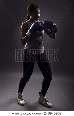 Black Female Wearing Boxing Gloves Training Or Exercising.  She Is Posing With Punches And Depicts F