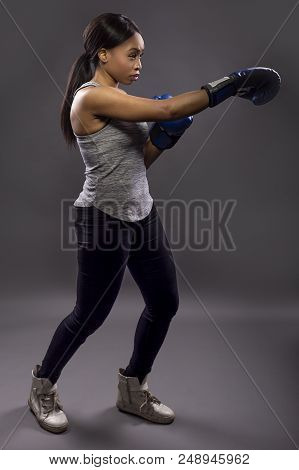 Black Female Wearing Boxing Gloves Training Or Exercising.  She Is Posing With Punches And Depicts F