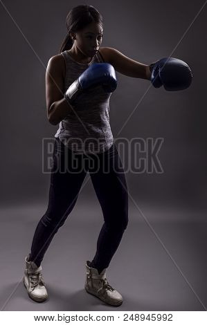 Black Female Wearing Boxing Gloves Training Or Exercising.  She Is Posing With Punches And Depicts F