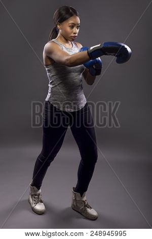 Black Female Wearing Boxing Gloves Training Or Exercising.  She Is Posing With Punches And Depicts F