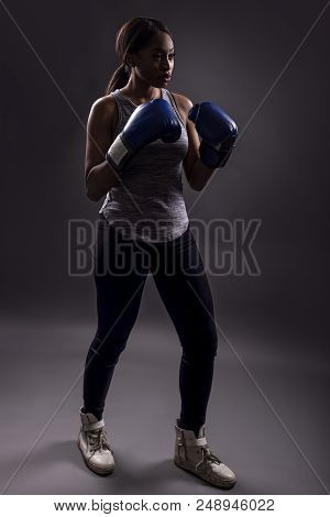 Black Female Wearing Boxing Gloves Training Or Exercising.  She Is Posing With Punches And Depicts F