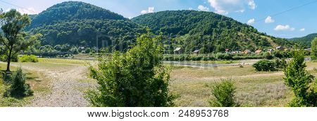A Mountain Landscape With A Bridge Over The River And A Settlement On The Shore On A Summer Clear Da