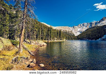 Lake Verna with rocks and mountains around at autumn. Rocky Mountain National Park in Colorado, USA. 
