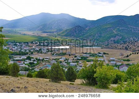 Industrial Unpopular Small Town In The Valley Of Mountains With Small Ponds And Green Fields