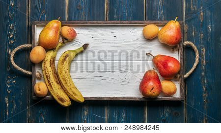 Fresh Fruit On A White Wooden Tray: Banatas, Pears, Apricots. Countryside Setting. Top View. Copy Sp