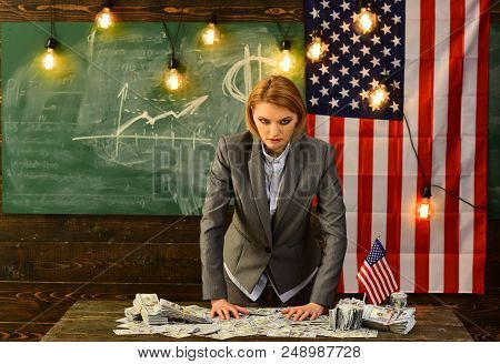 Serious Woman Dressed In Suits With An American Flag Holding A Bunch Of Dollar.