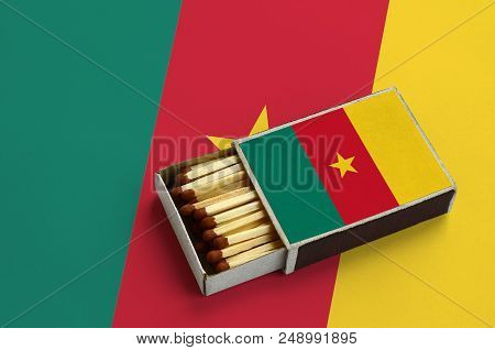 Cameroon Flag  Is Shown In An Open Matchbox, Which Is Filled With Matches And Lies On A Large Flag.