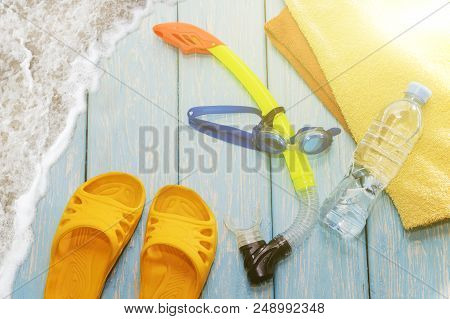 Glasses Diving Mask And Snorkel, Clear Water Bottle, Bright Slates On Wooden Blue Background