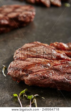 Hot Grilled Whole Alternative Steak on Black Stone Background. Fresh Juicy Medium Rare Beef Grillsteak. Barbecue Meat  Close Up