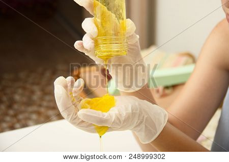 How To Make Slime. A Female Hand In A Protective Glove Holds Yellow Homemade Slime Is A Children's T