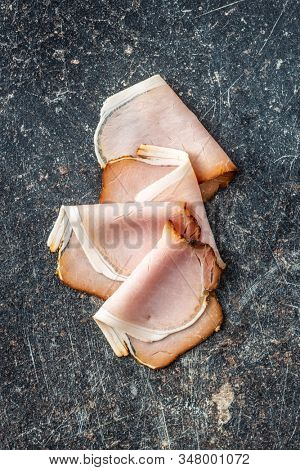 Sliced smoked ham. Tasty pork meat on old kitchen table. Top view.