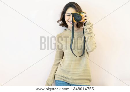 Portrait Of Pretty Cool Young Asian Woman With Instant Camera  Posing On Beige Background.