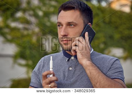 Electronic Cigarettes, Cigarette Technology. Tobacco Iqos System. Close-up Of A Man Smoking An Elect