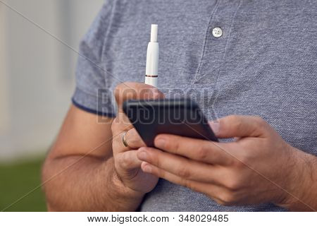 Electronic Cigarettes, Cigarette Technology. Tobacco Iqos System. Close-up Of A Man Smoking An Elect