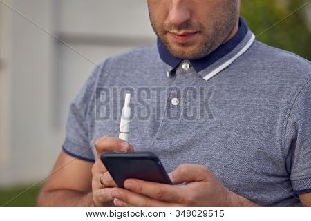 Electronic Cigarettes, Cigarette Technology. Tobacco Iqos System. Close-up Of A Man Smoking An Elect