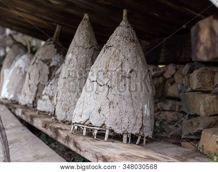 Old Traditional Beehive Knitted With Wicker And Covered With Mud On Wooden Shelf