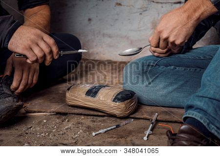 Two Shabby  Men Preparing Drug Injection In Slums.